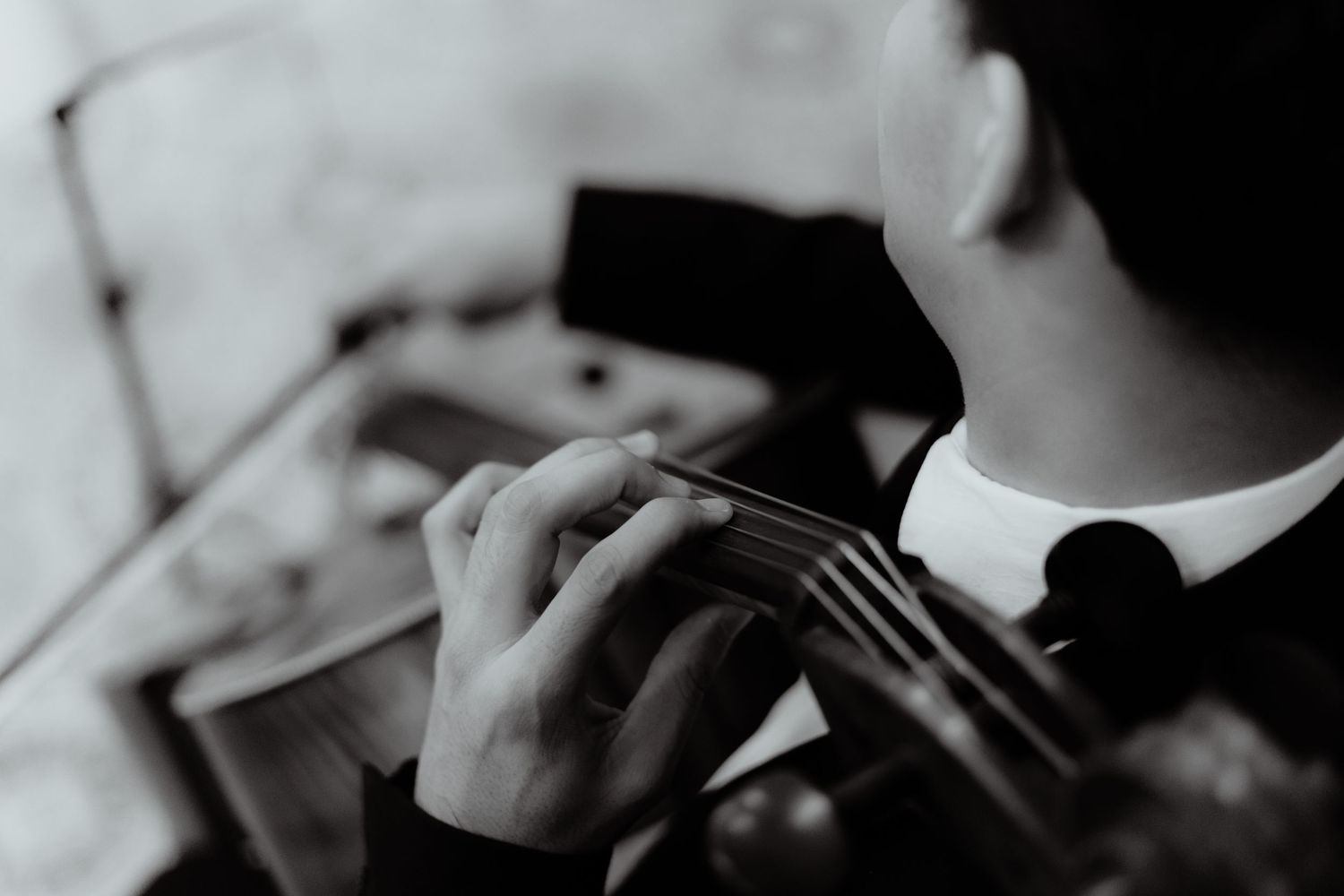 Close-up black and white shot of hands playing a violin.