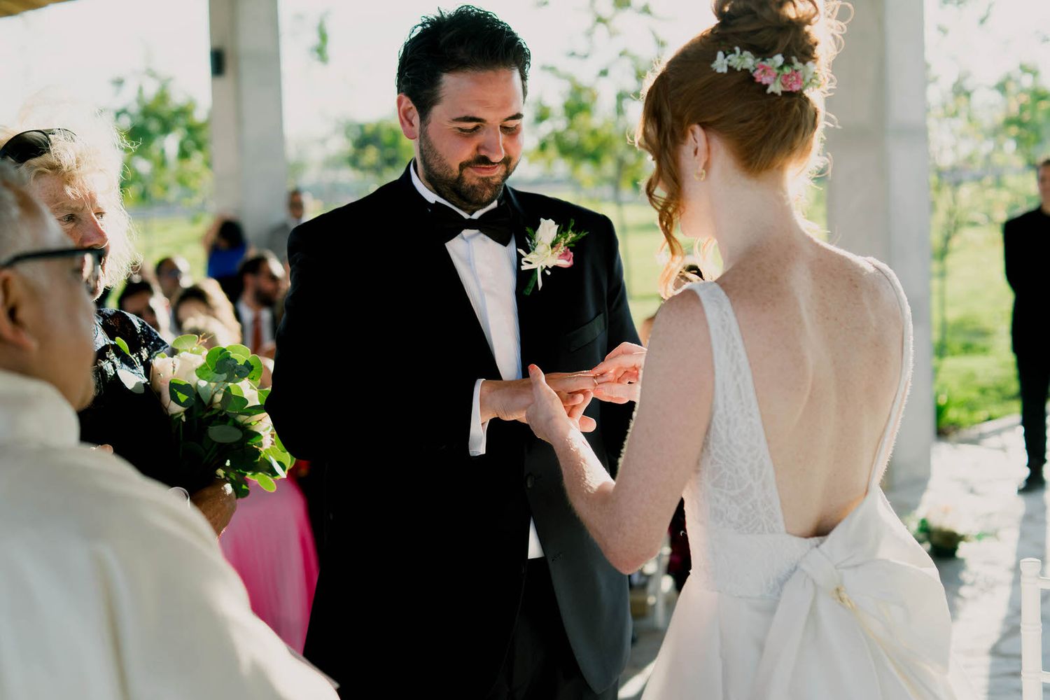 Intimate wedding ceremony moment under rustic wooden pavilion.