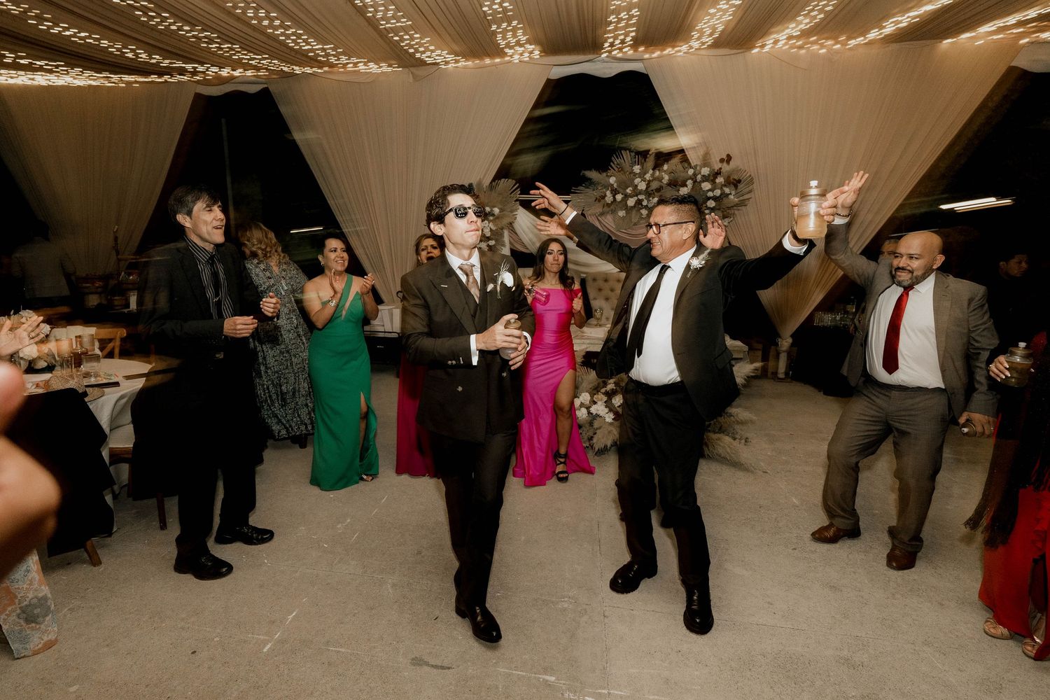 Wedding guests dancing in formation during a choreographed celebration moment.