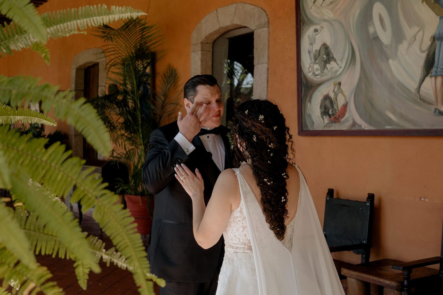 Newlyweds share a romantic dance moment in a Spanish-style venue.