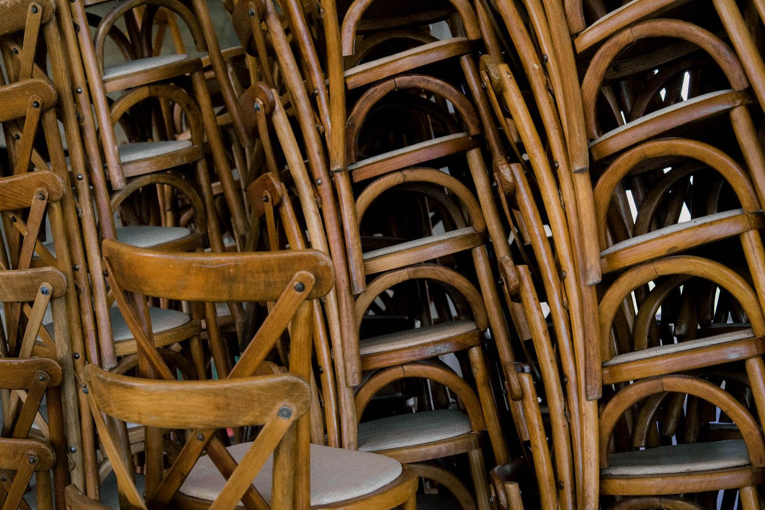 Rows of wooden chairs arranged for a ceremony with natural lighting.