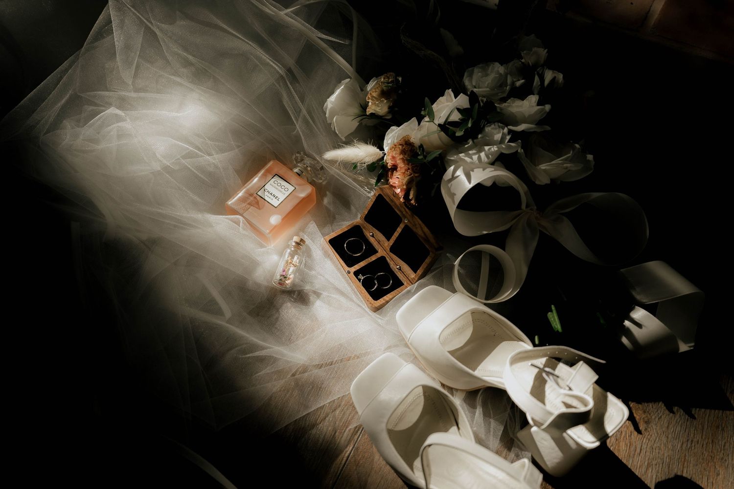 Wedding details artistically captured with dramatic lighting and soft focus effects.