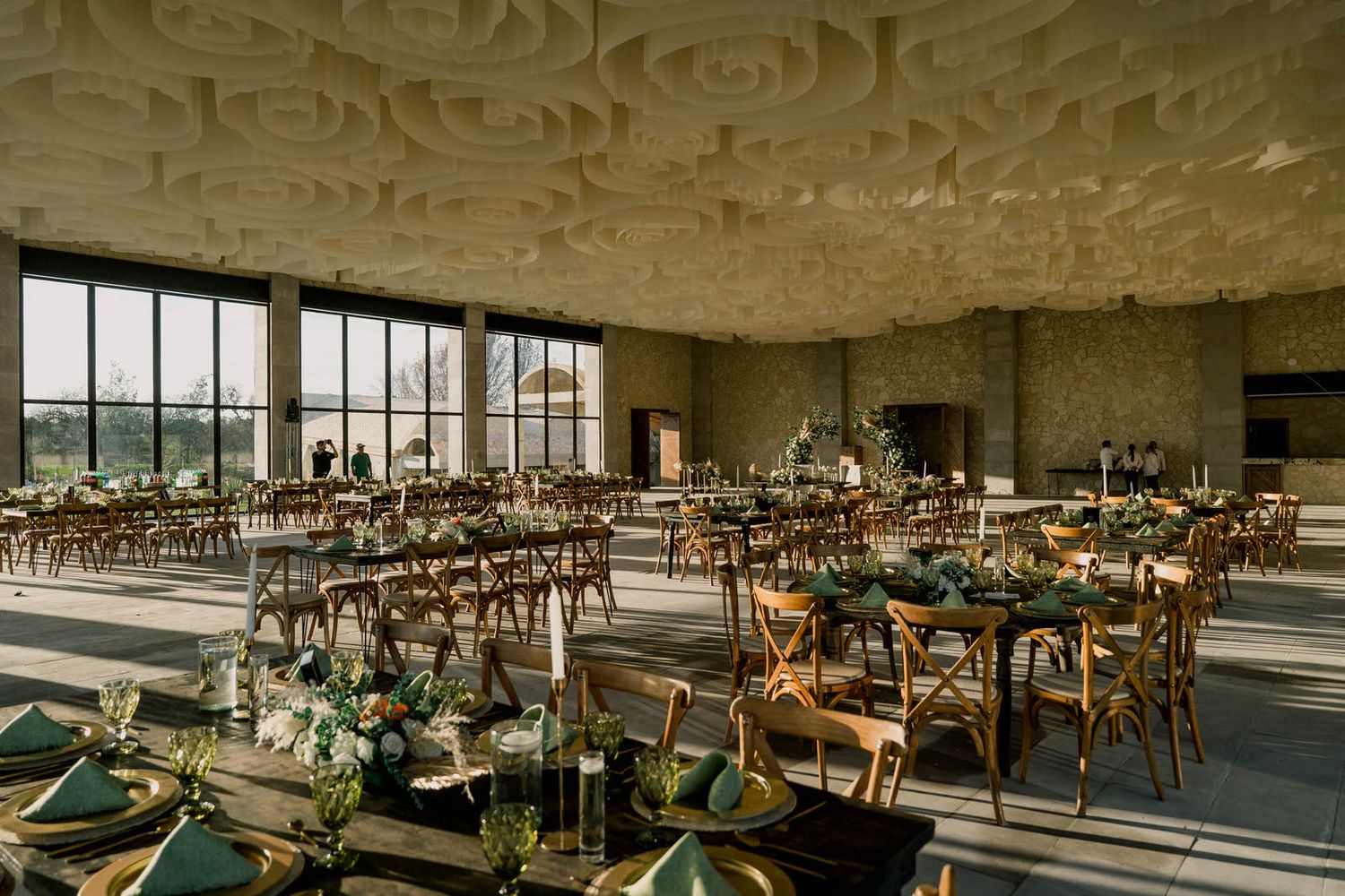 Modern industrial event space with rows of elegant table settings and natural light.