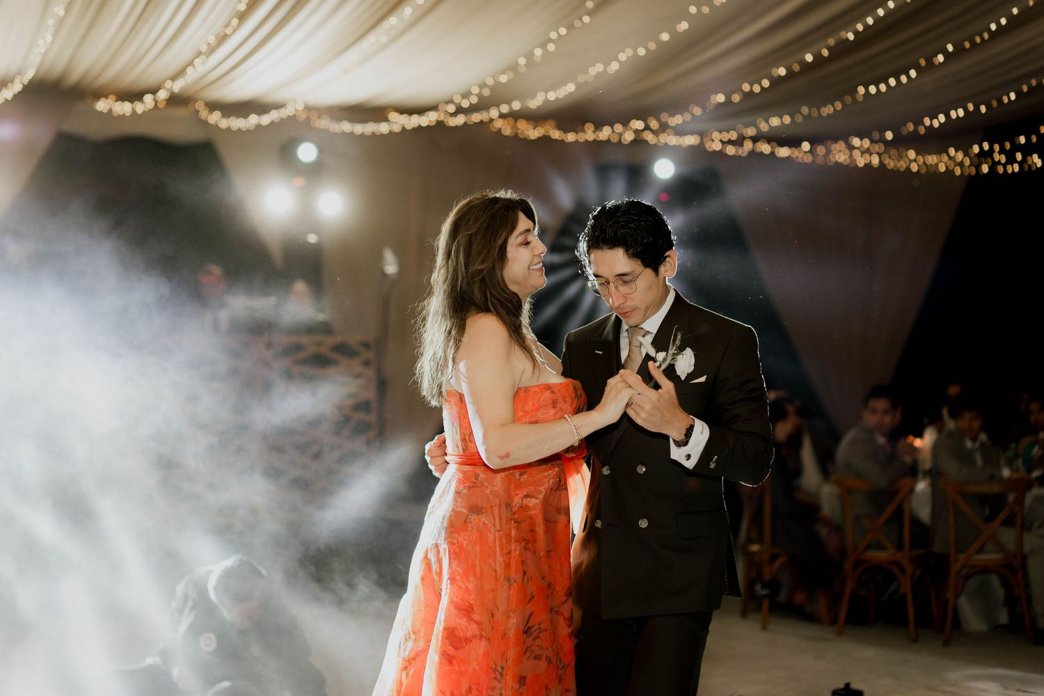 Wedding dance scene with orange dress and dramatic lighting effects.