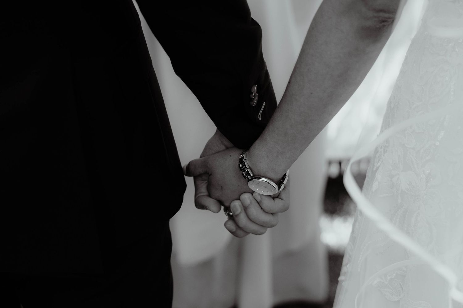 Intimate moments captured during wedding ceremony showing details of formal attire.