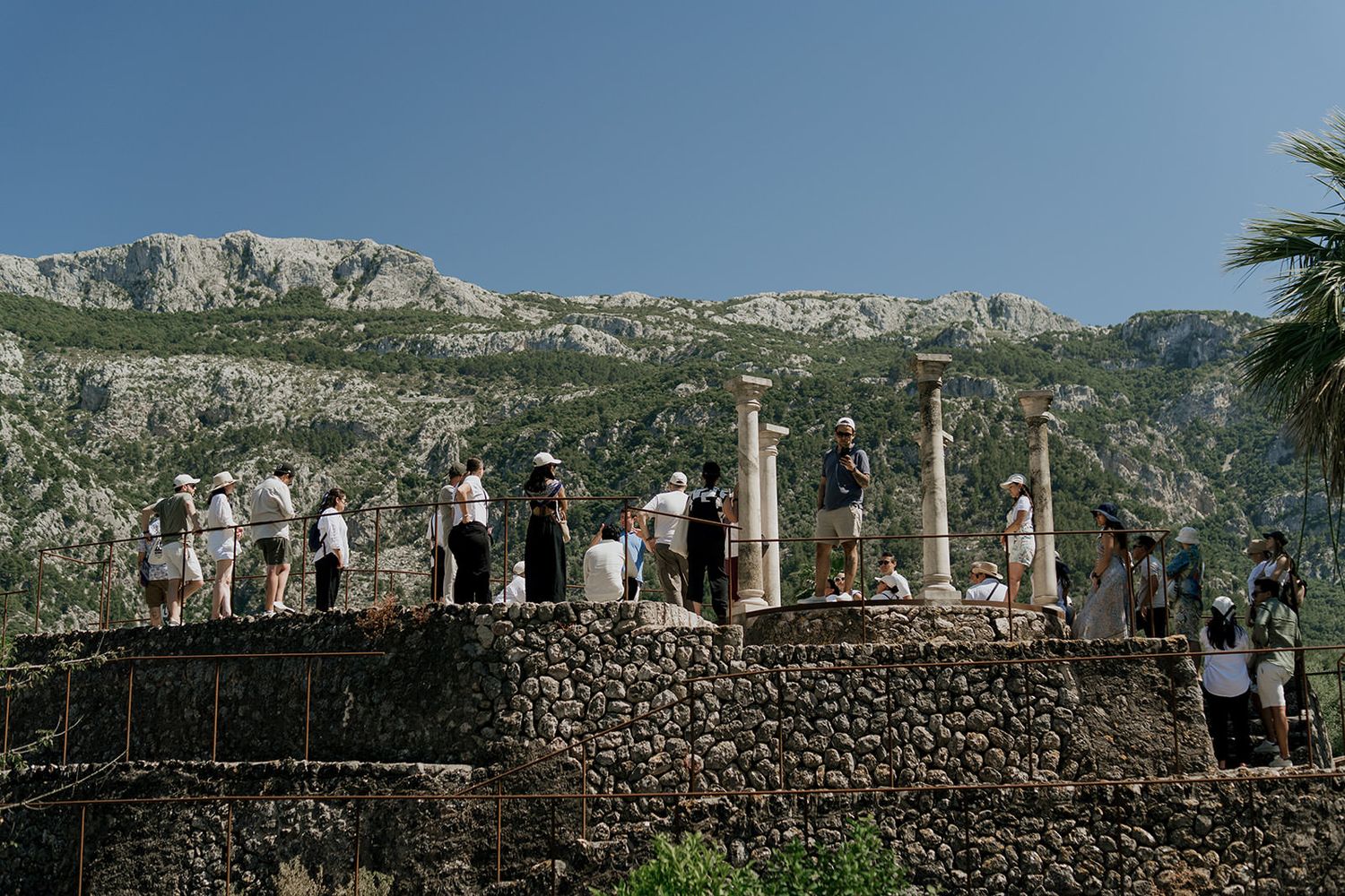 Panoramic mountain landscape with stone walls and Mediterranean architecture.