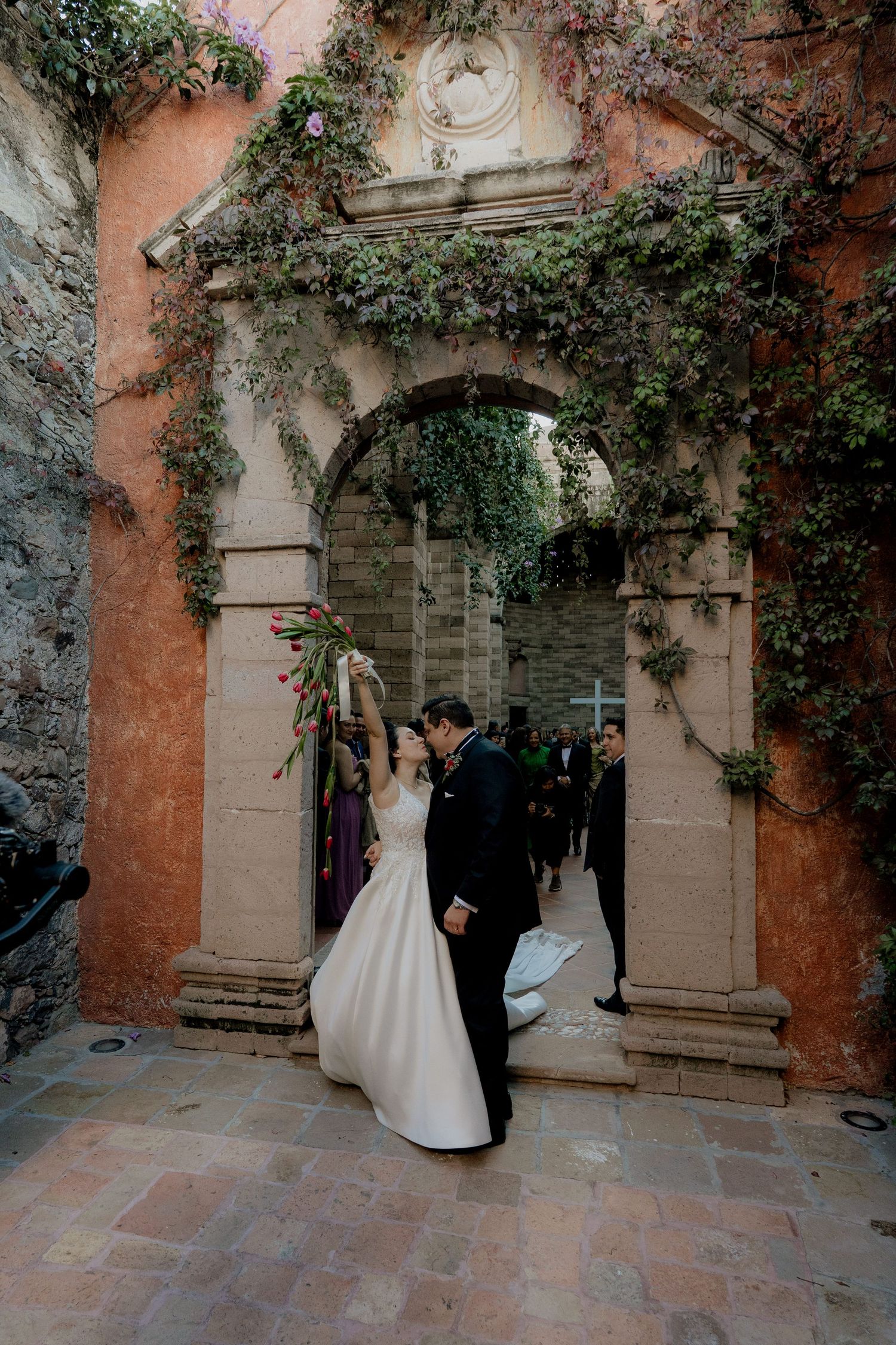 Stone courtyard with ivy-covered walls creates romantic wedding ceremony backdrop.