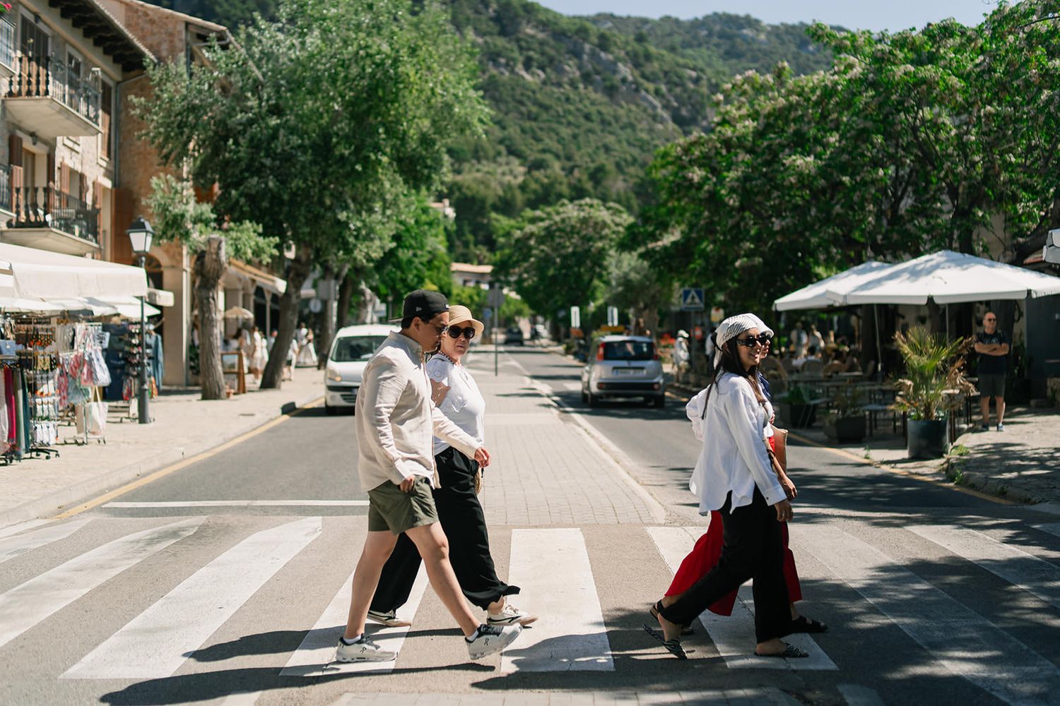 Series of street scenes showing a person walking along a sunny Mediterranean town with mountains in background.