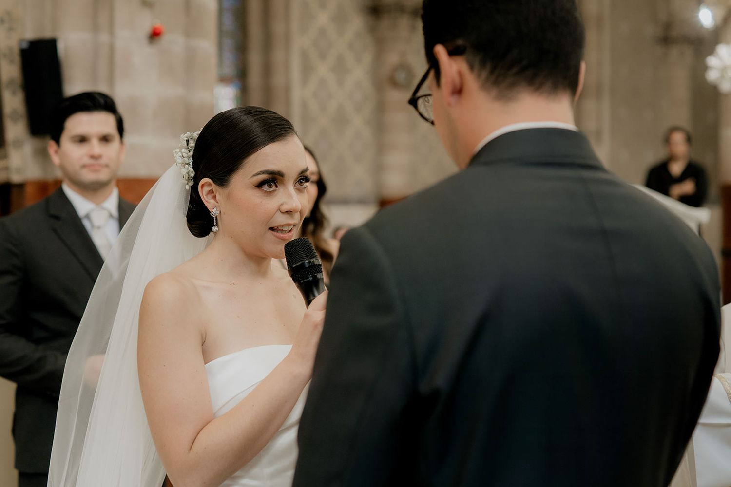 Bride gazes at groom during emotional church wedding vows ceremony.
