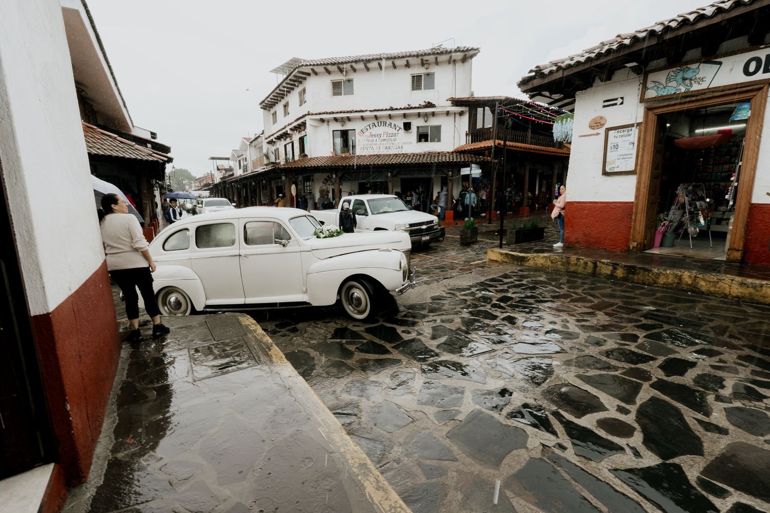 Rainy courtyard with wet cobblestone pavement and colonial architecture.
