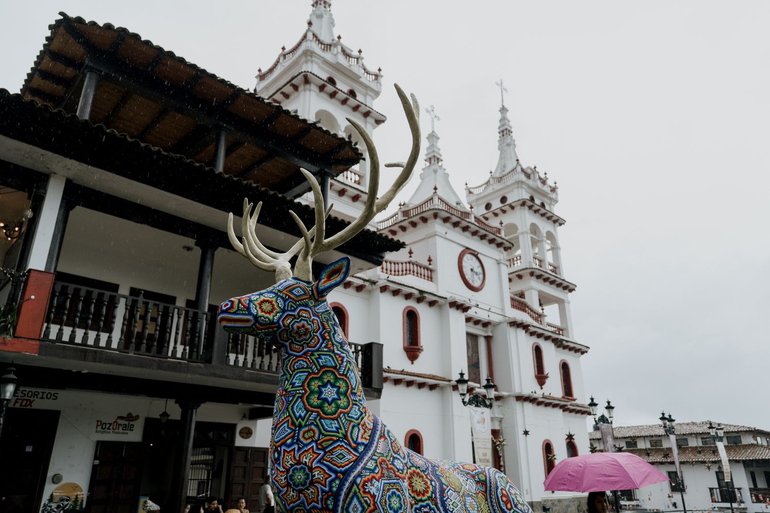 White church spires rise against a cloudy sky with ornate architectural details and crosses on top.