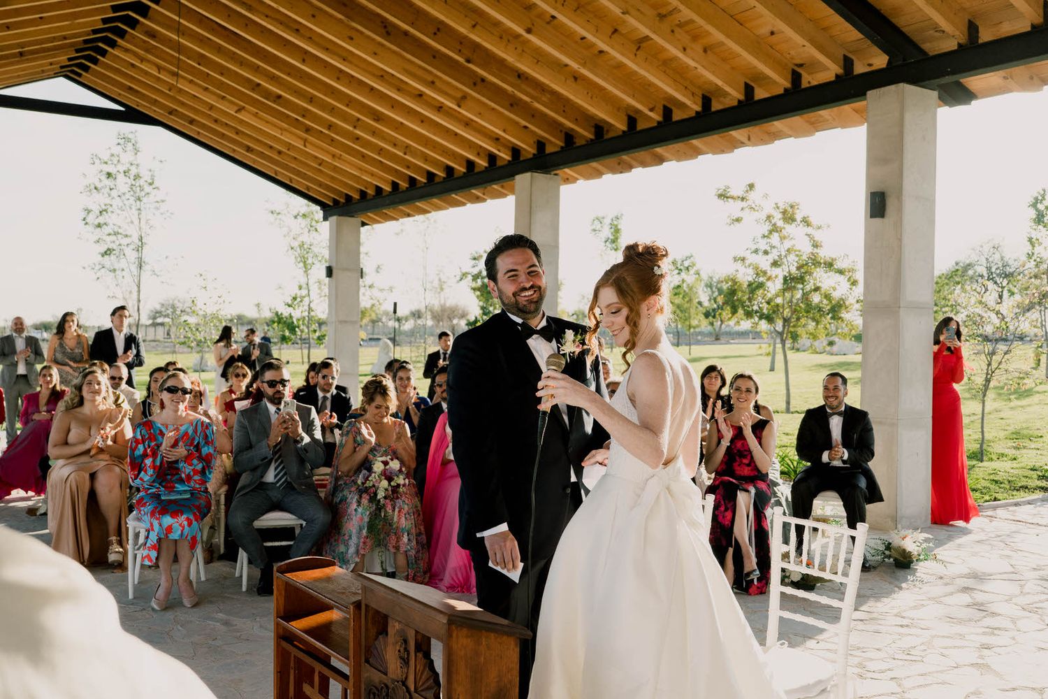 Wedding ceremony in progress at an elegant outdoor pavilion with mountain views.