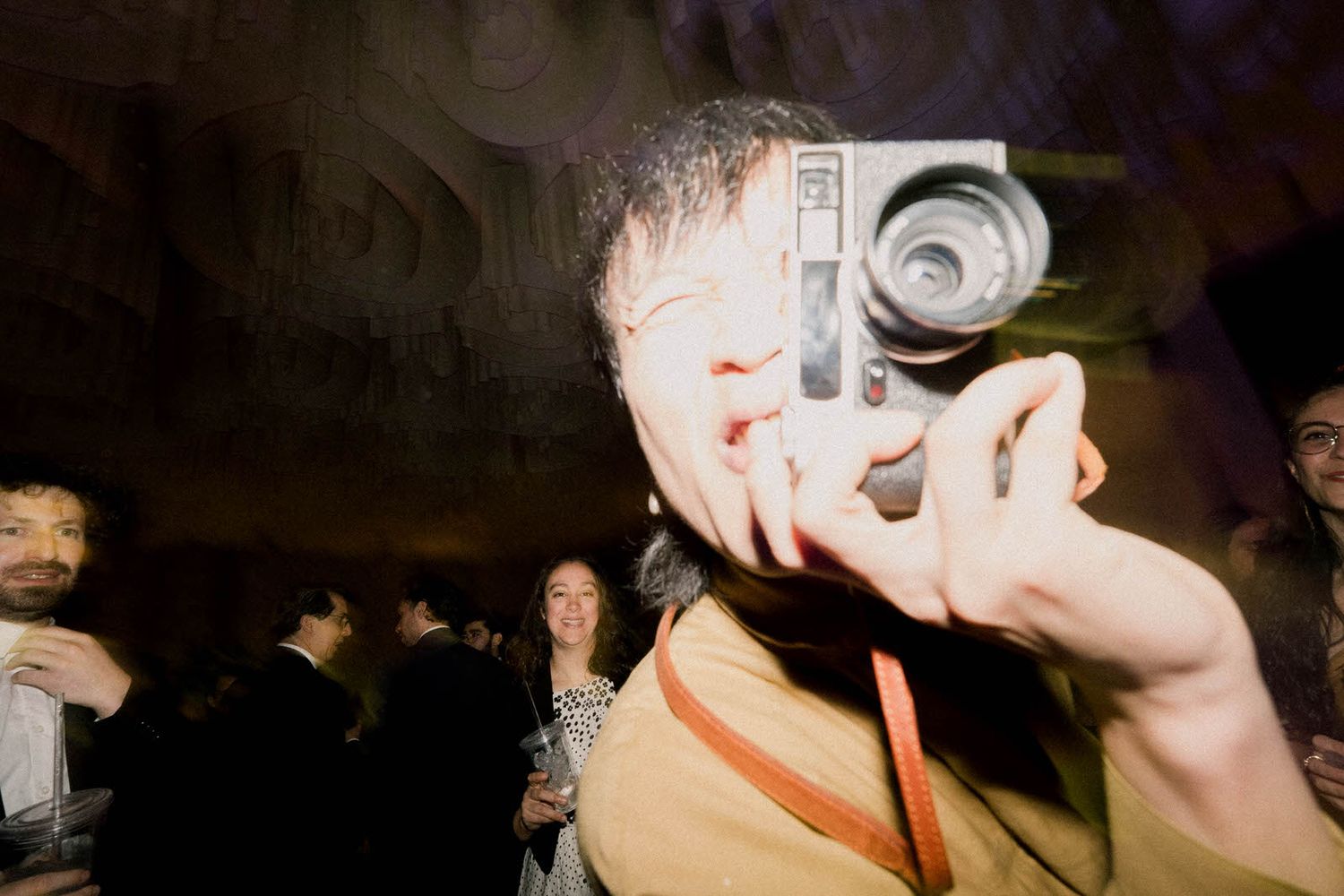 Lively dance party with people enjoying themselves under dark ambient lighting.