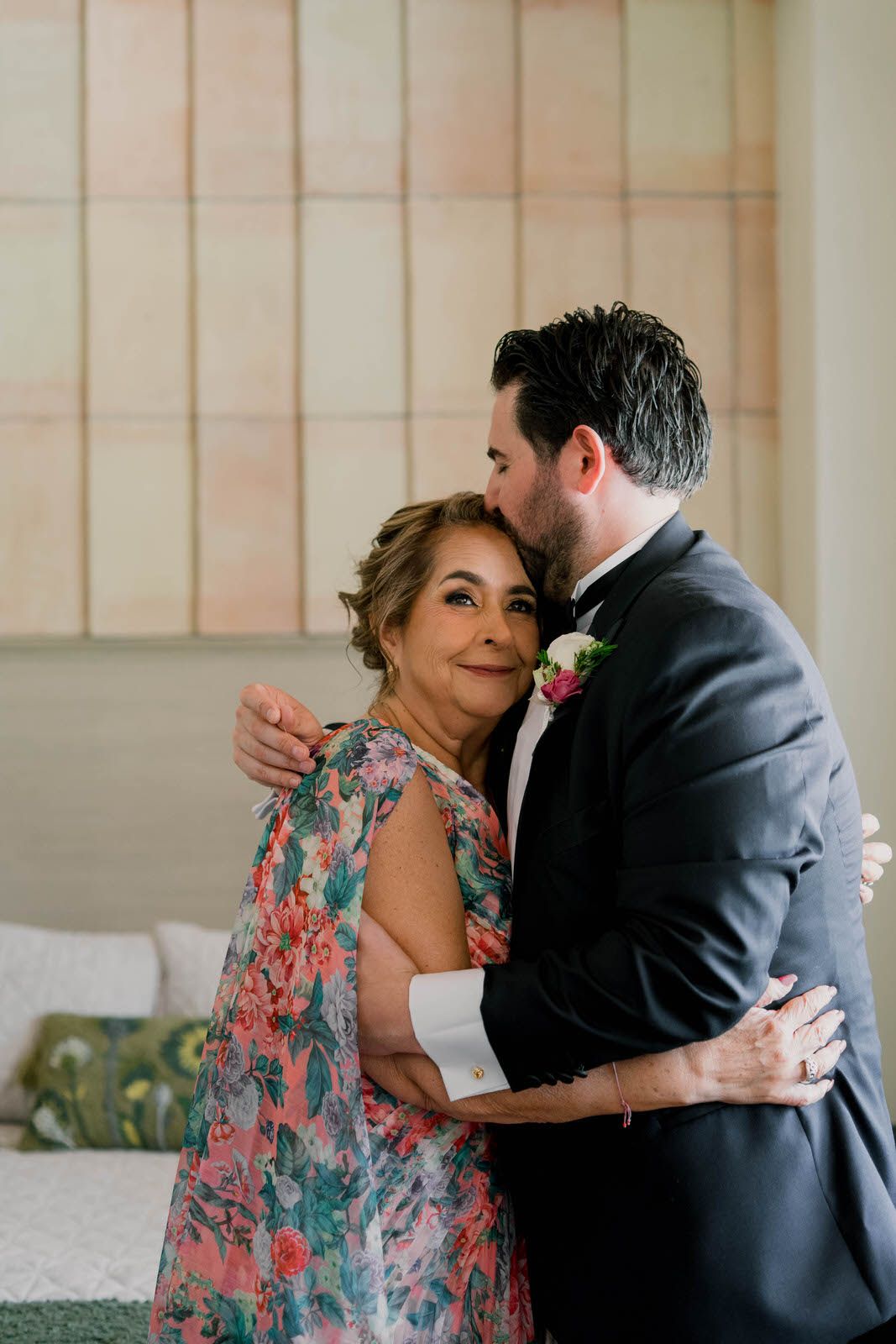 A tender embrace captured in a sunlit room with floral patterns and soft furnishings.