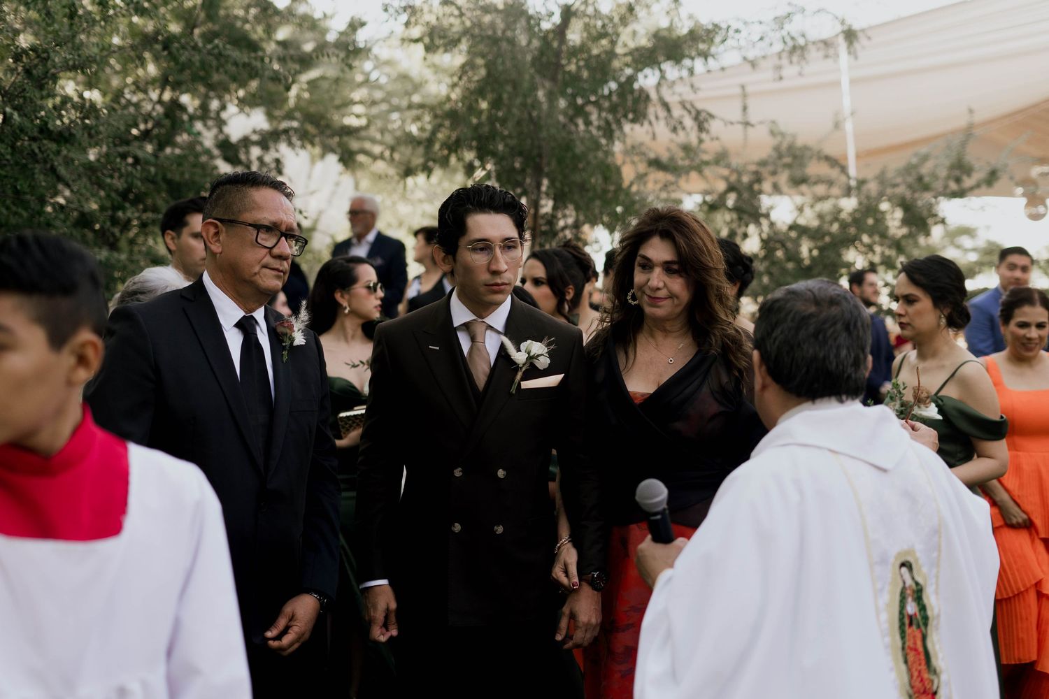 Wedding guests gathered outdoors for a formal celebration in formal attire.