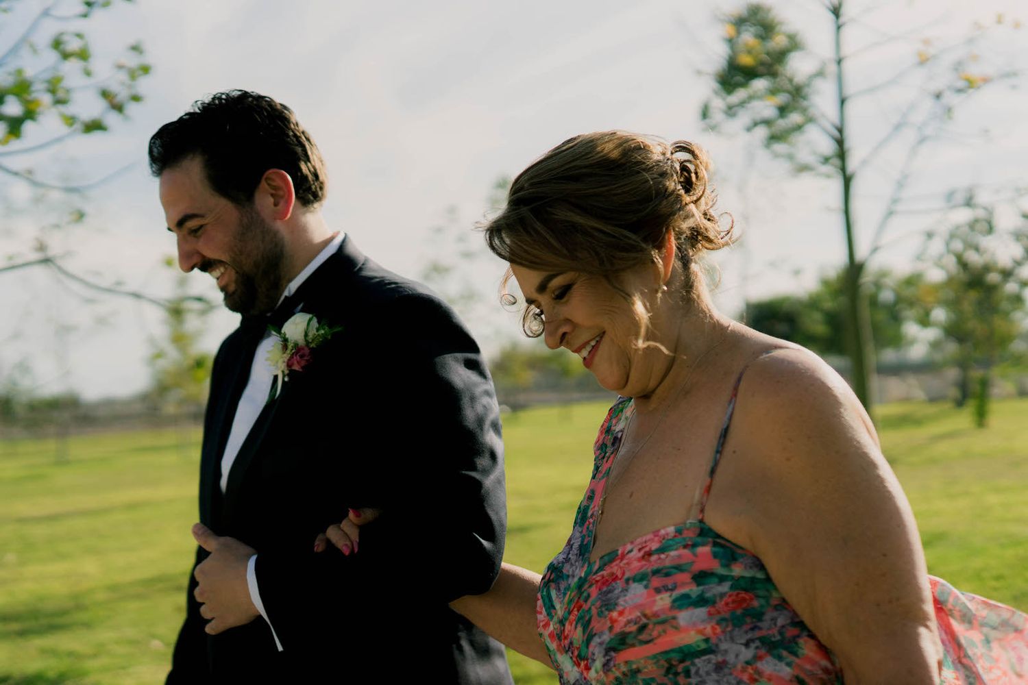 Couple sharing a romantic moment under a covered outdoor venue with natural lighting.