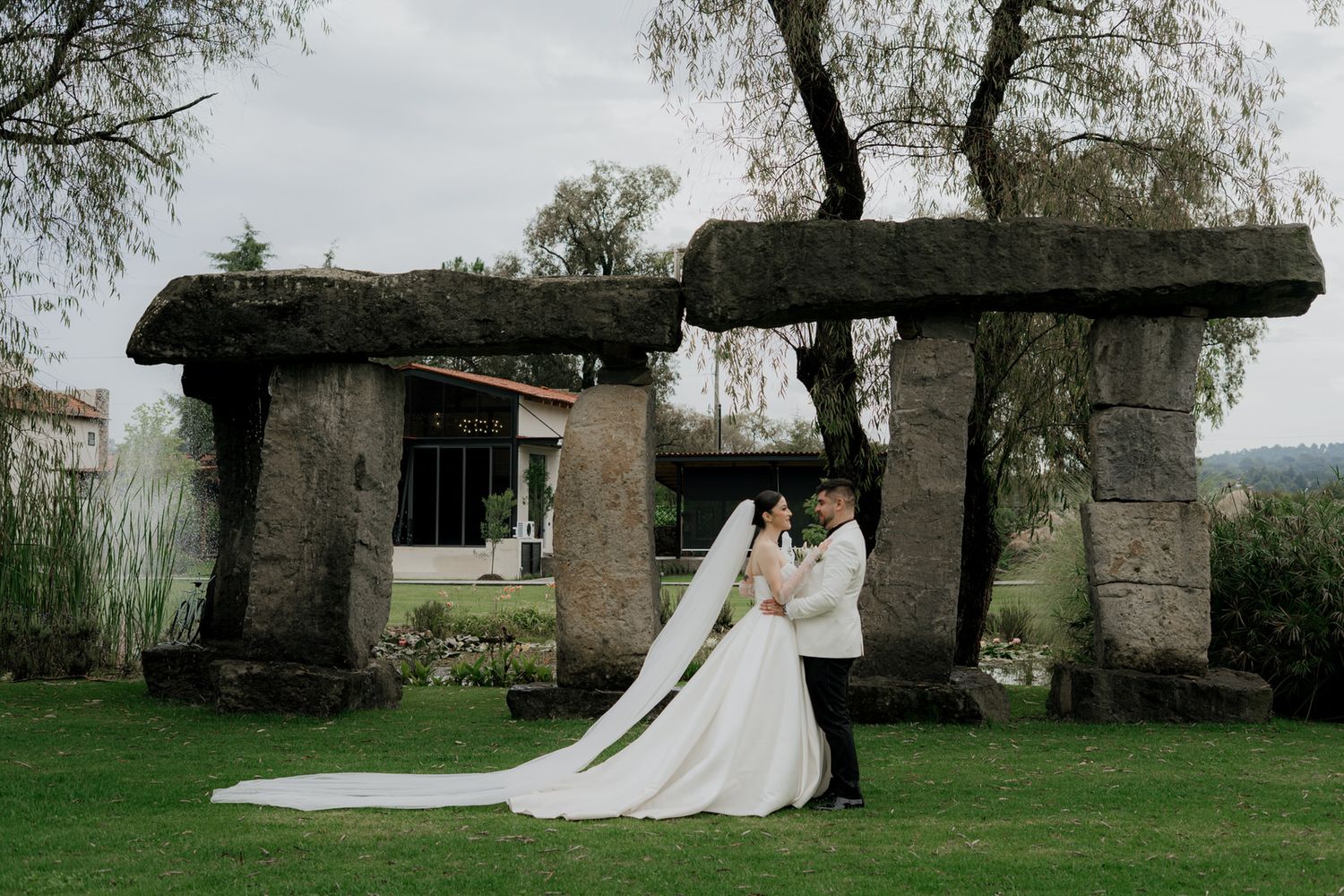 Elegant wedding photos taken outdoors featuring a flowing white dress against a rustic stone backdrop.