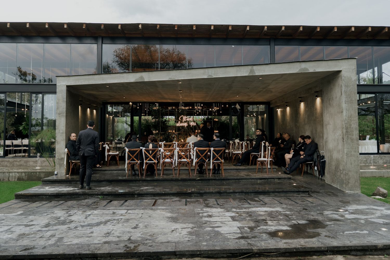 Modern concrete architectural exterior of an event venue with glass windows.