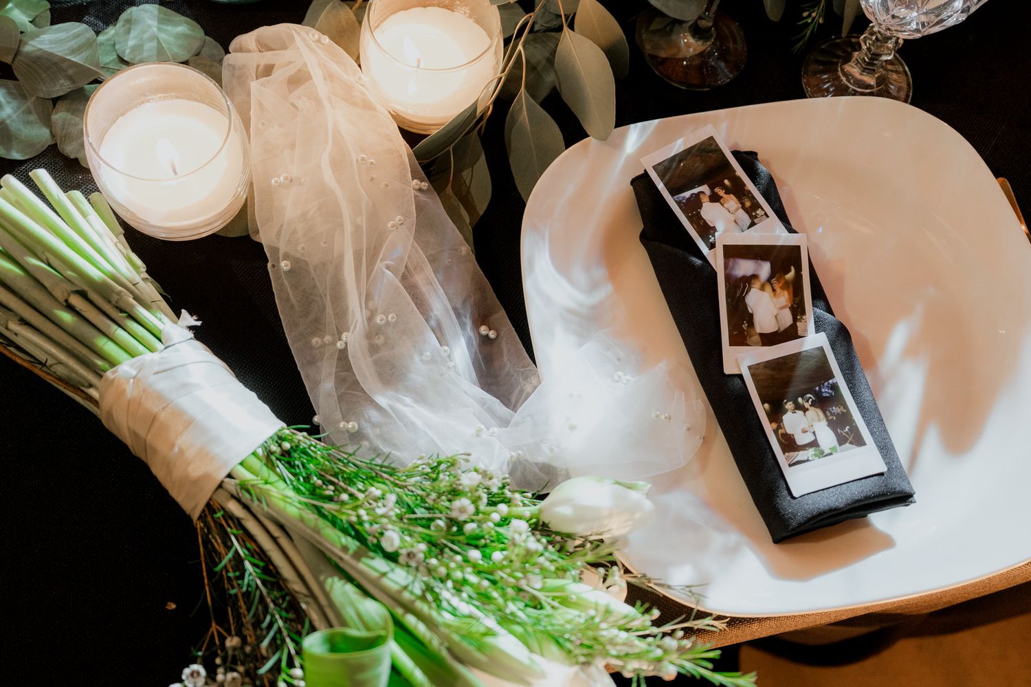 Wedding preparation details with white dress and floral arrangements in natural light.