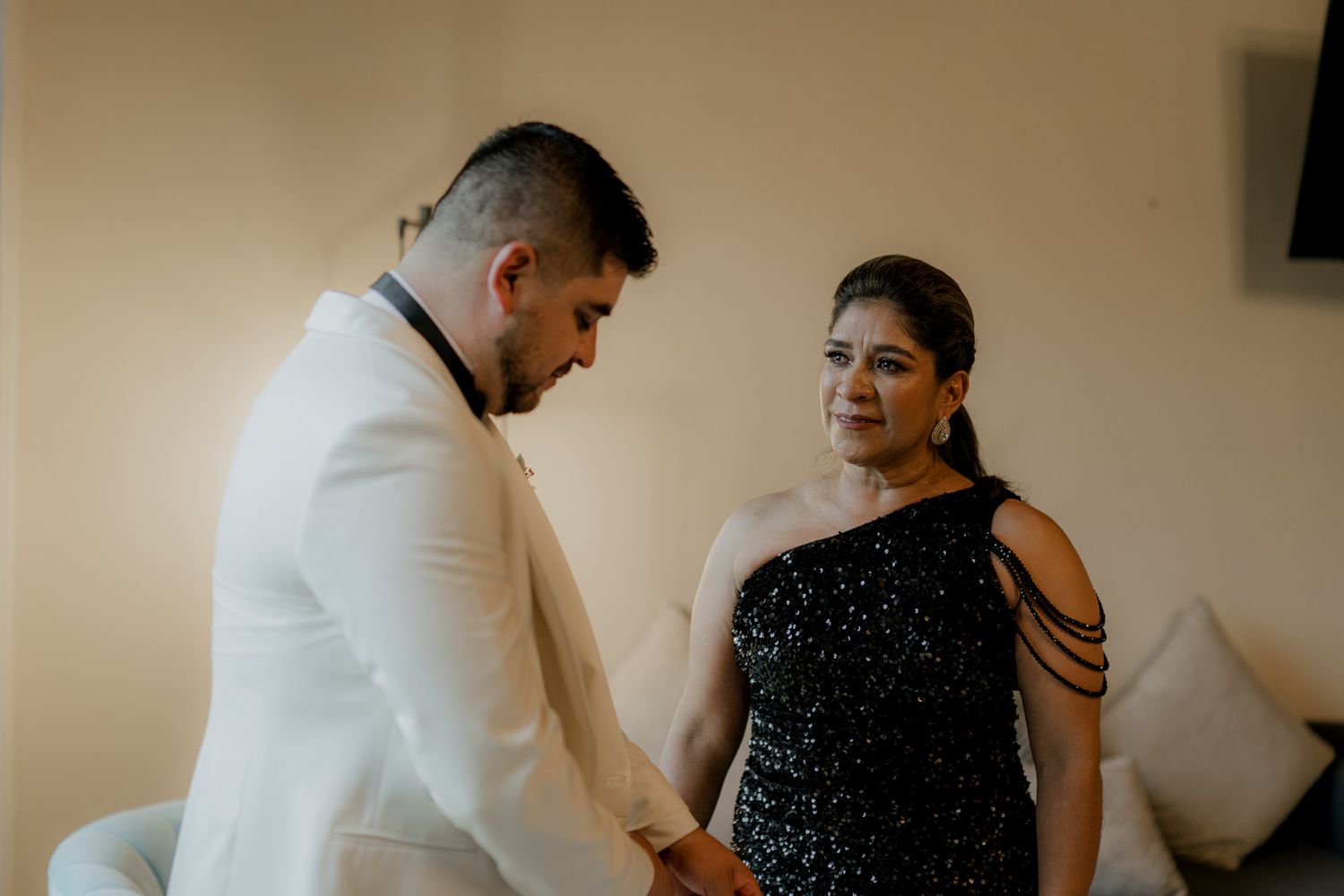 Wedding party members share joyful moments while getting ready in a modern venue.