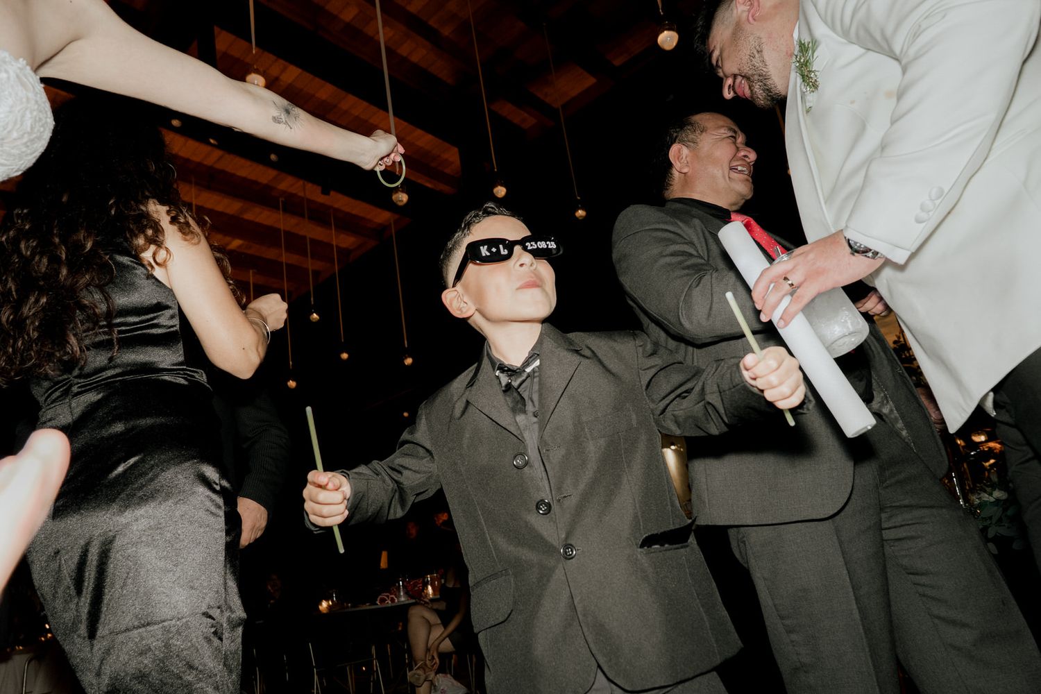 Guests enjoying themselves on a dark dance floor at a nighttime celebration.