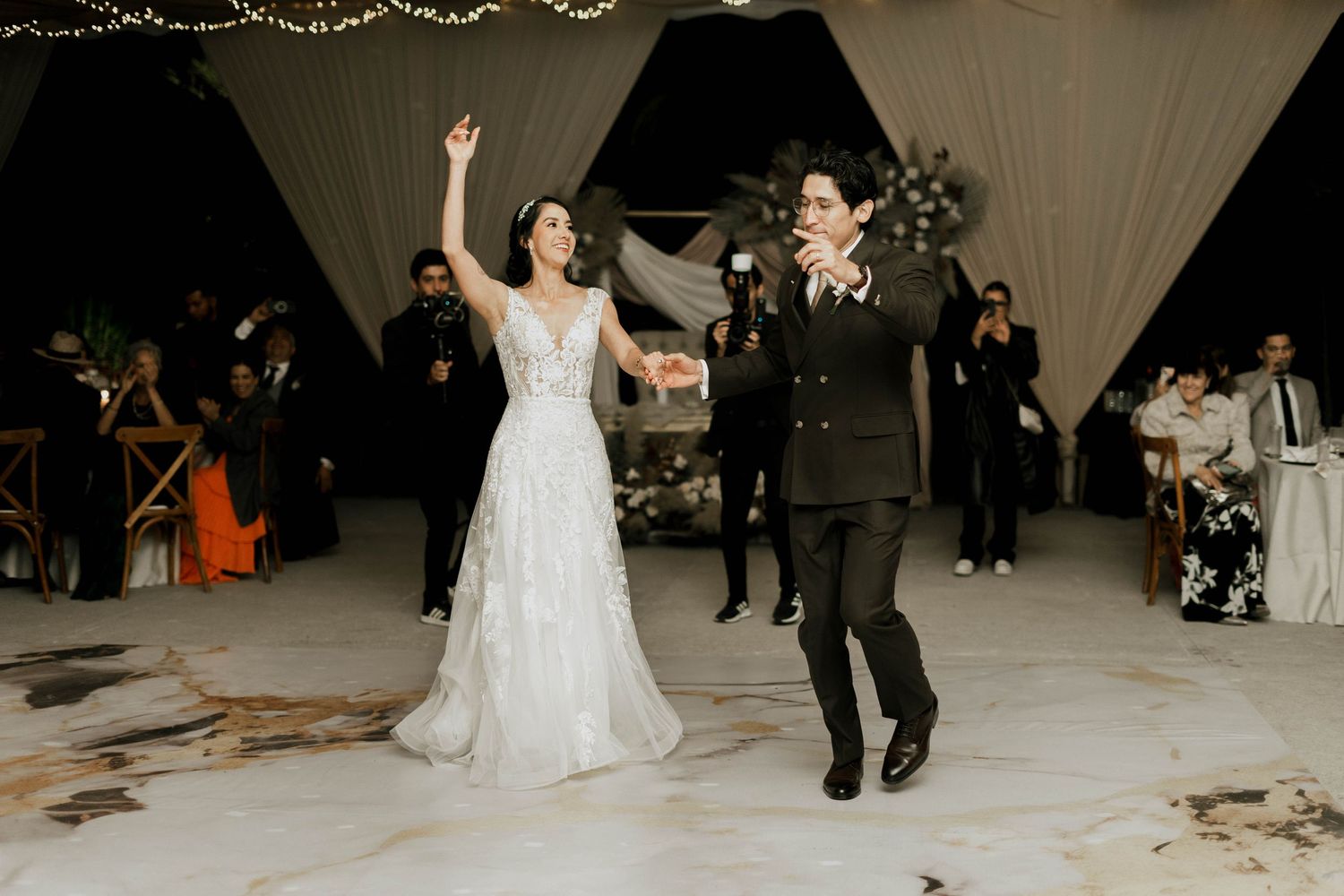Couple dancing their first dance at a wedding reception with pyrotechnic effects creating a magical atmosphere.