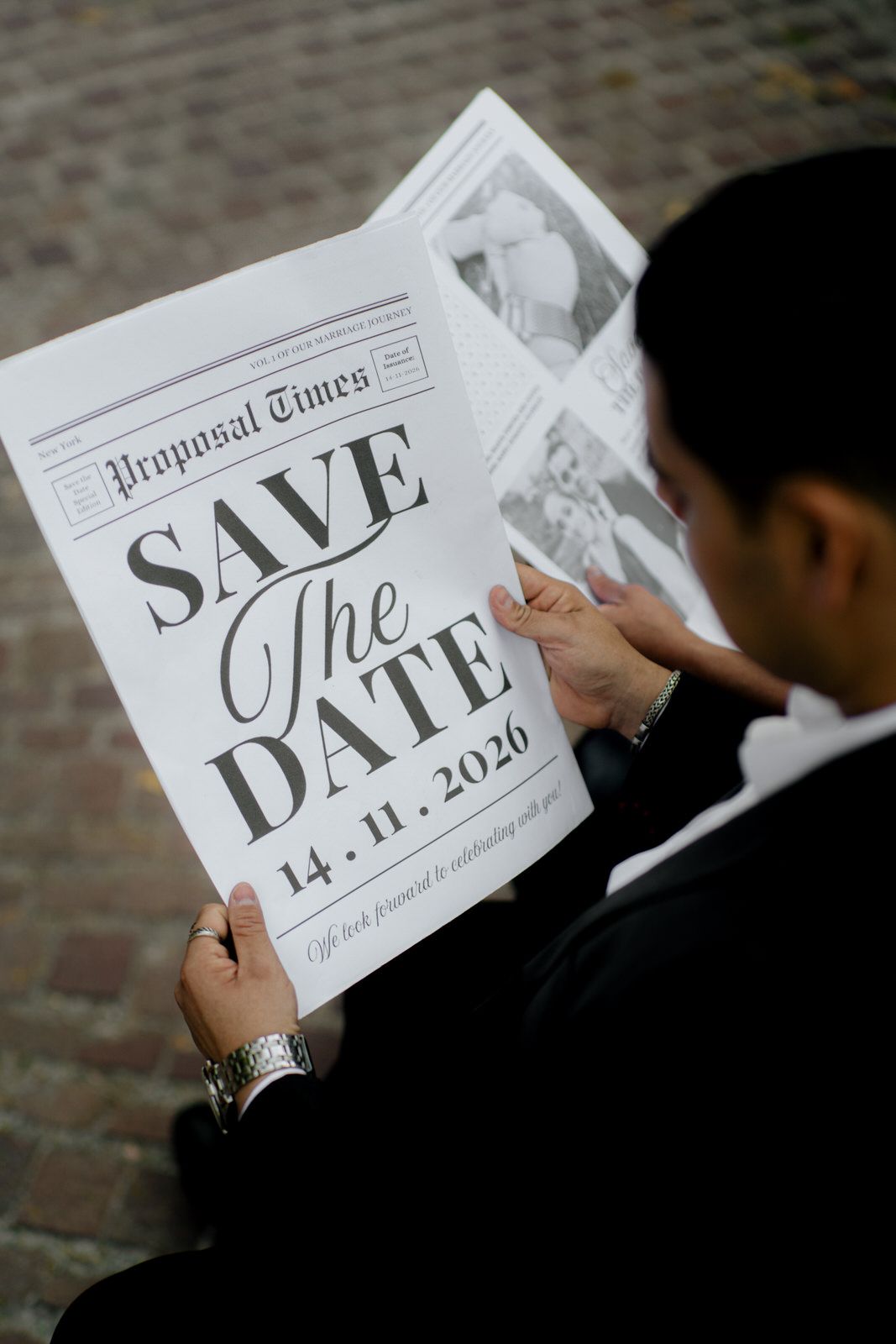 Close-up shot of hands holding a save-the-date card with the date 14.11.2020.