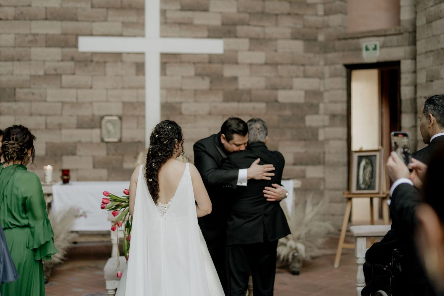 Wedding ceremony venue with stone walls and gathered attendees.
