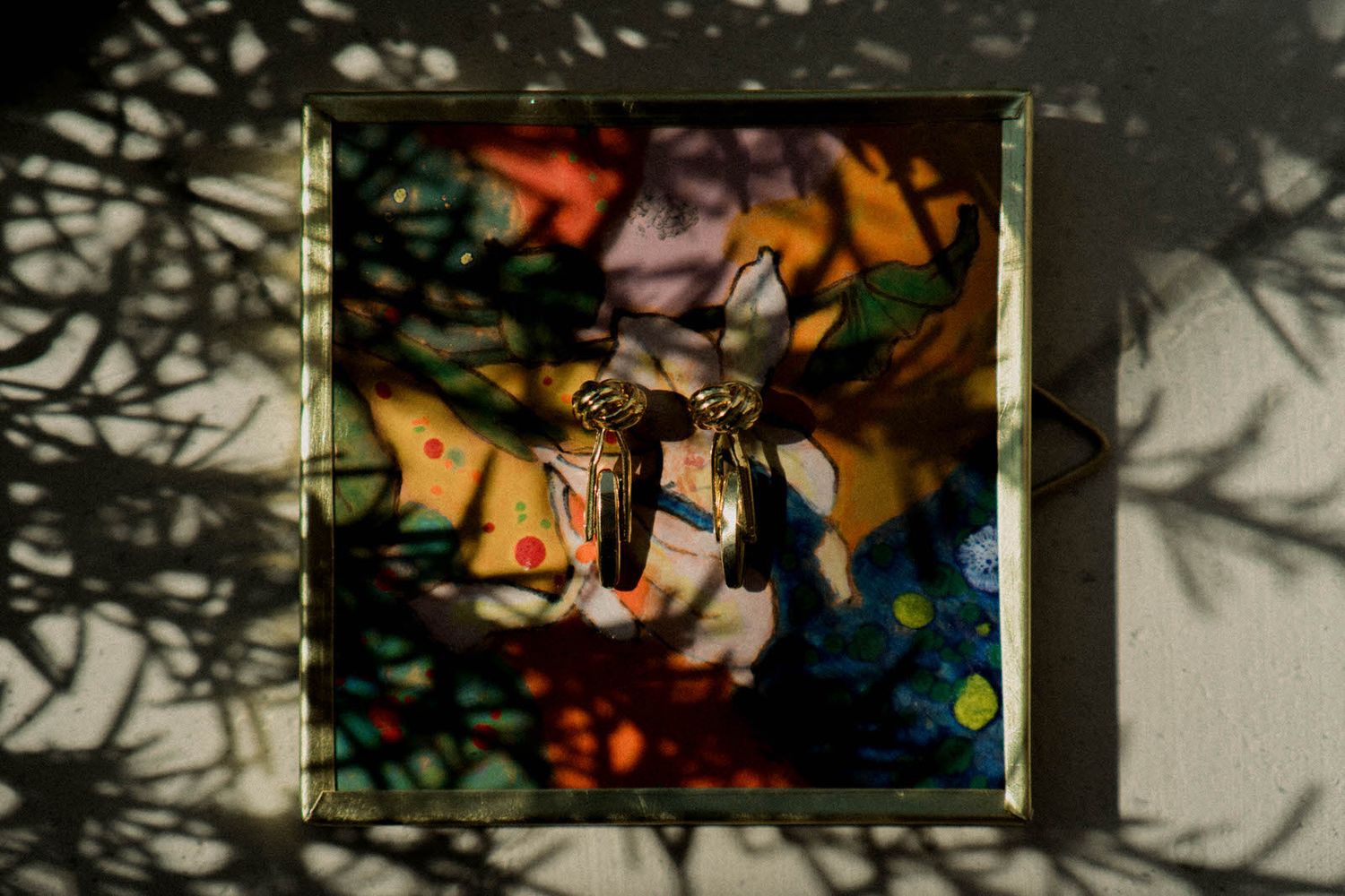 Abstract artwork in golden frames with dramatic shadow patterns.