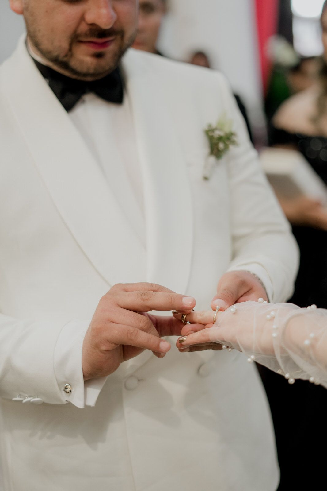 Close-up of hands exchanging rings during a wedding ceremony.