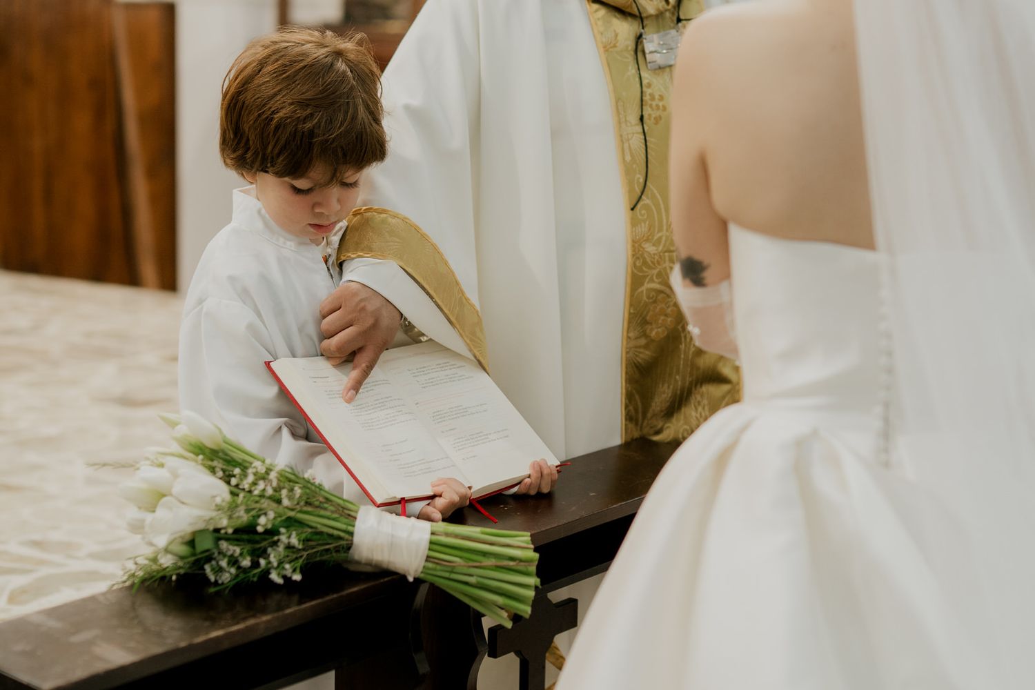 Close-up of white floral arrangements and ceremony details in a church setting.