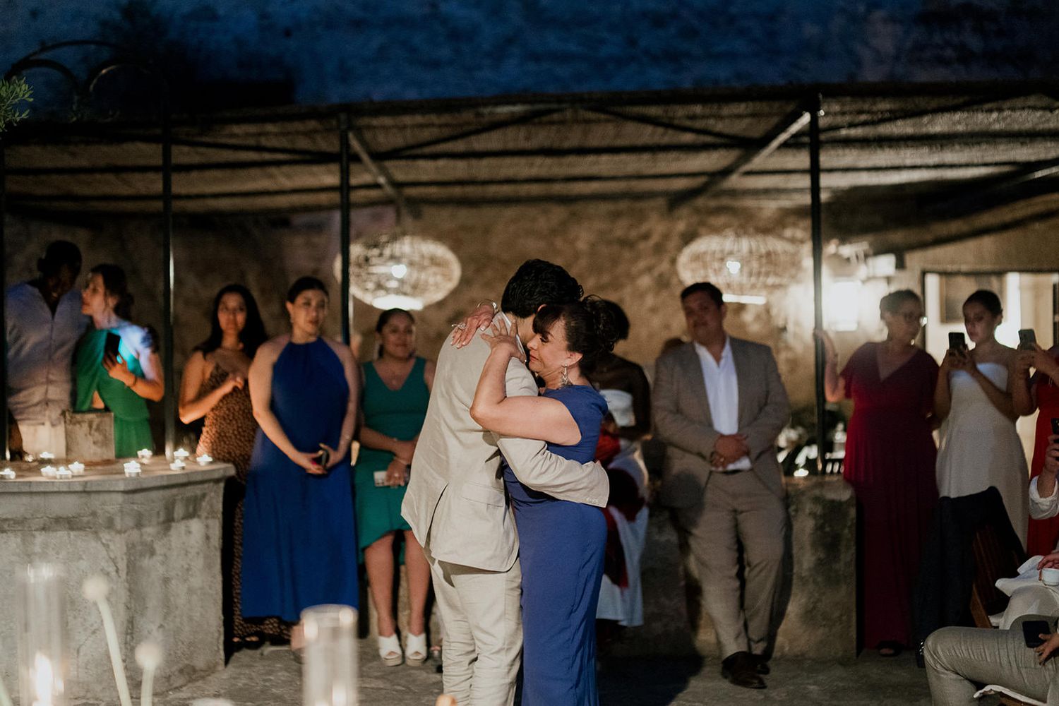 Wedding guests dance together during a reception celebration in a rustic barn venue.