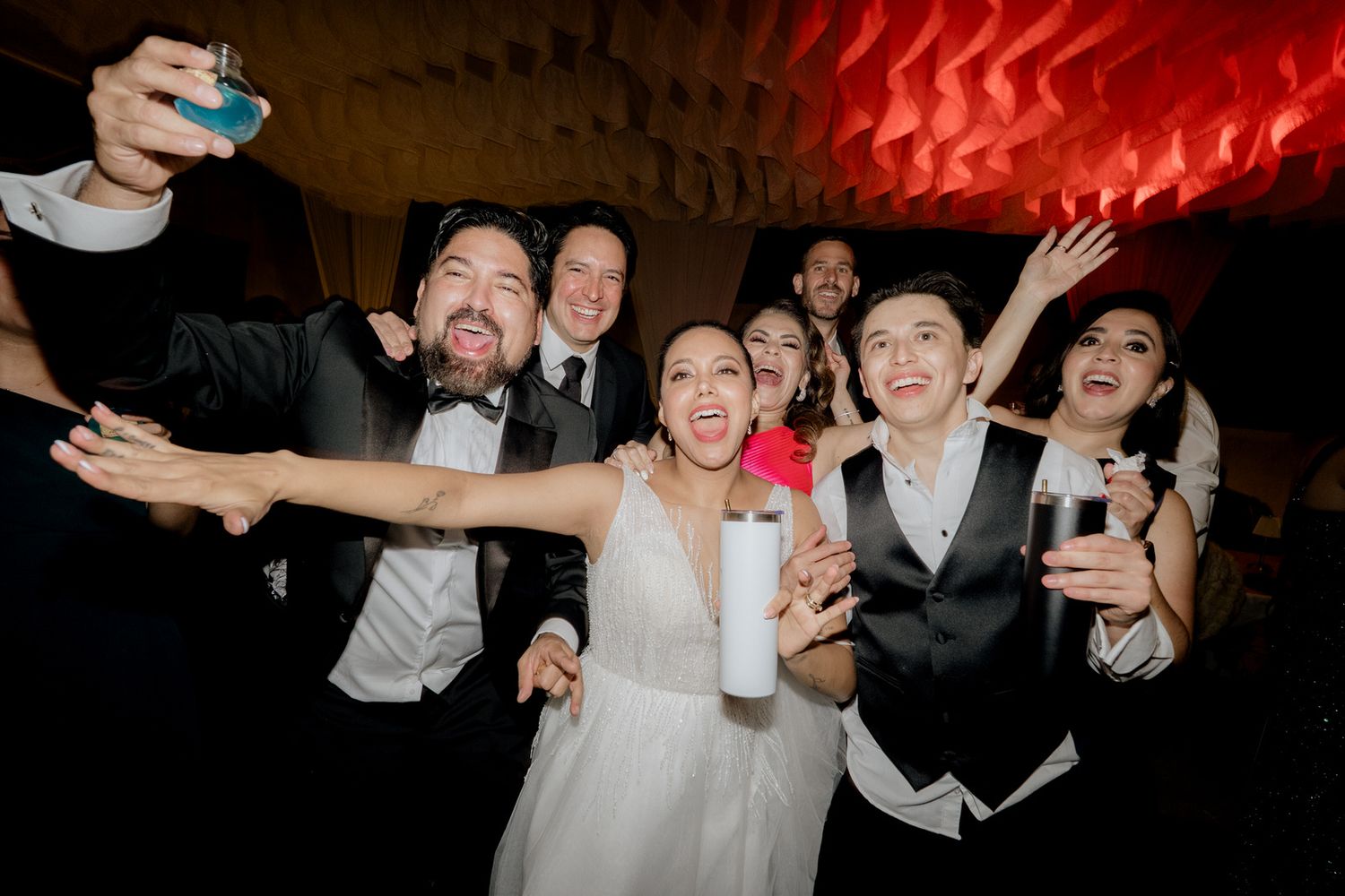 Bride and groom taking a selfie with friends at a fun wedding reception celebration.