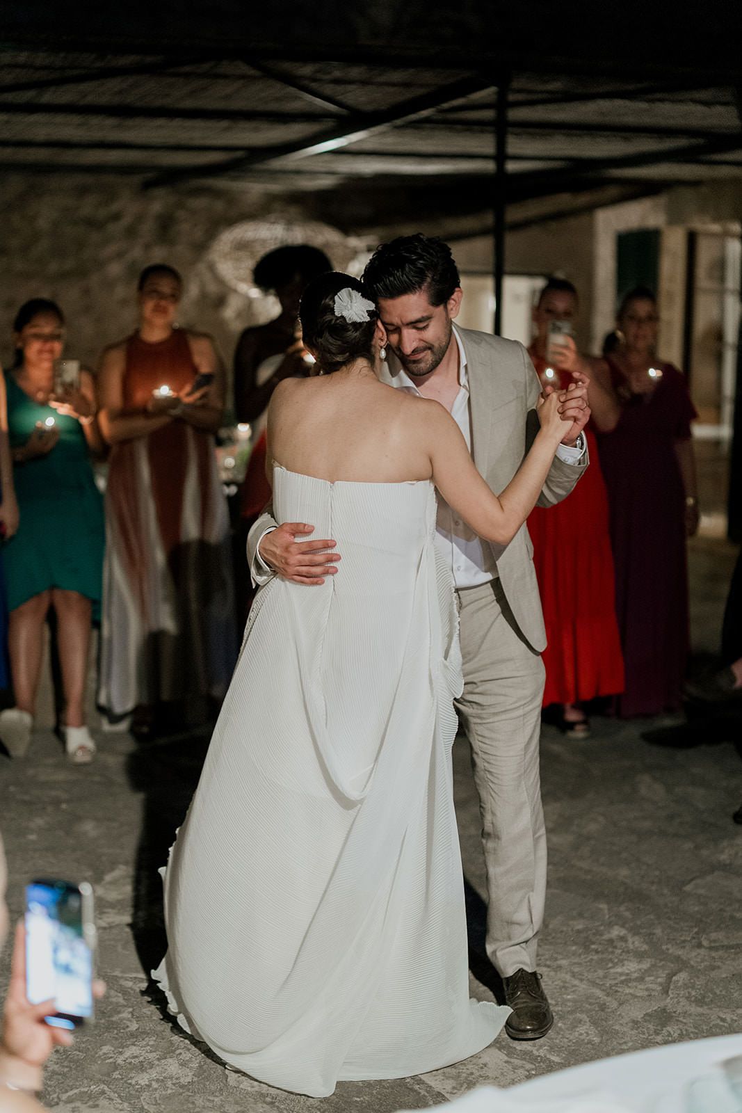 A couple shares a romantic dance on the floor during a wedding reception celebration.