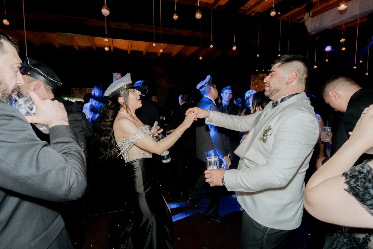 Party guests taking shots together in a dimly lit celebration space.