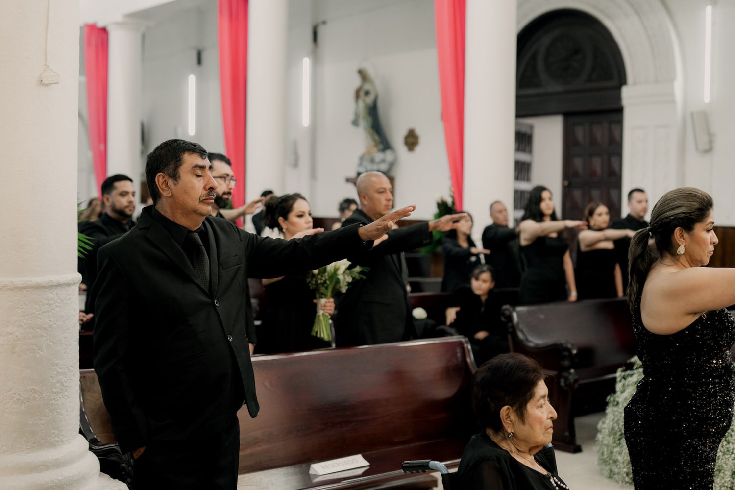 Orchestra performers seated in church pews during a wedding ceremony.