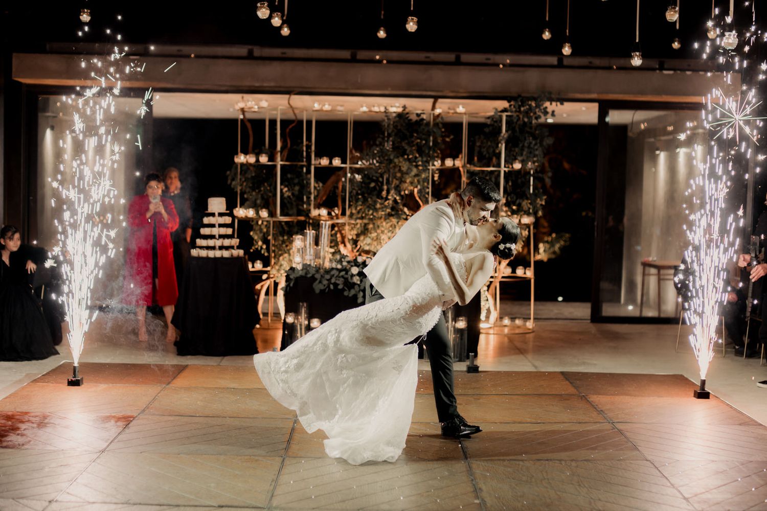 Wedding reception dance floor illuminated by sparklers and hanging lights creating a festive atmosphere.