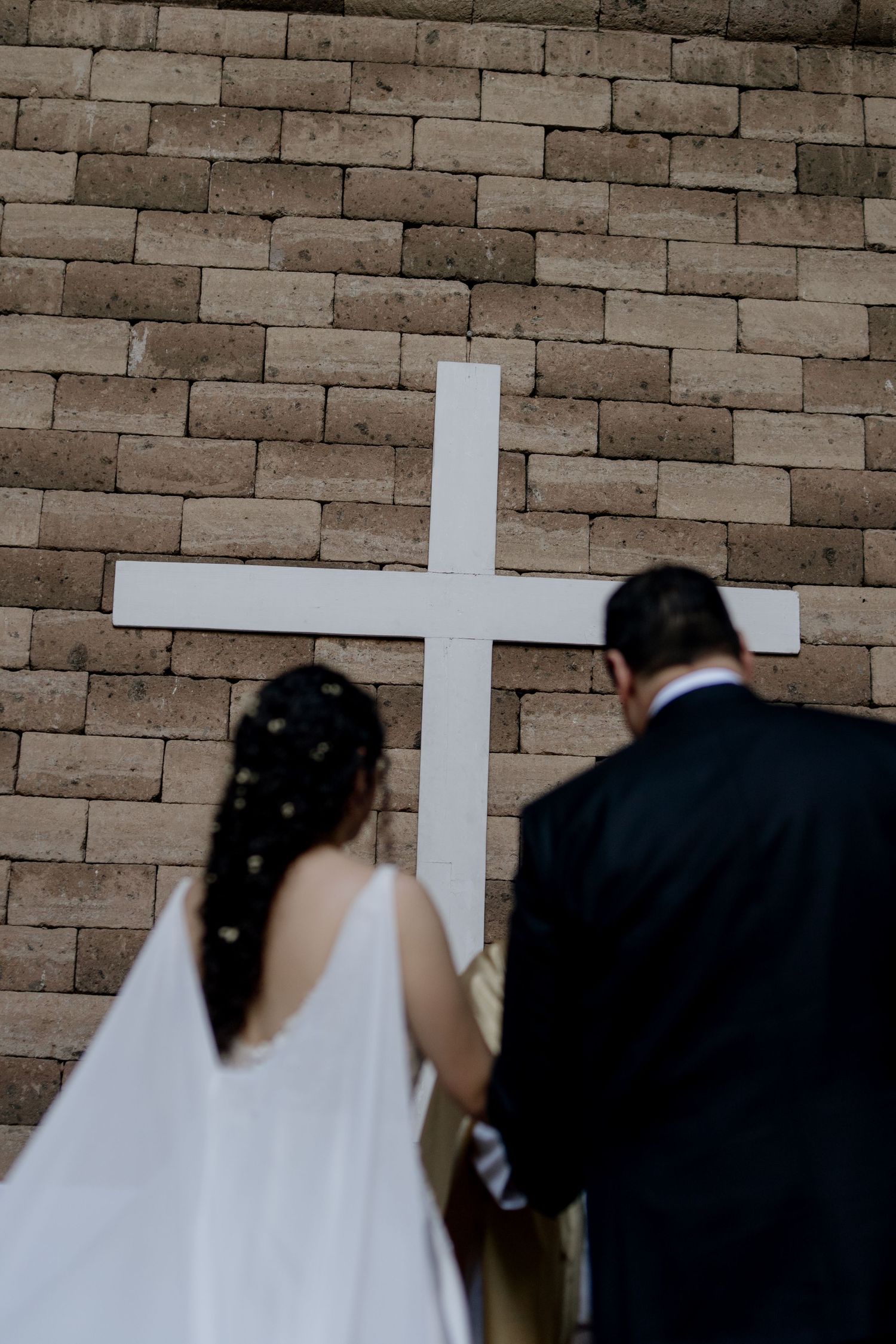 White crosses mounted on stone walls during a wedding ceremony.