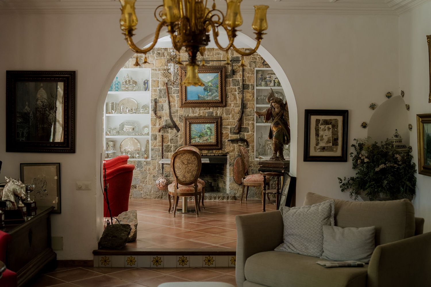 Elegant interior room with chandelier, ornate furnishings and framed artwork on display.