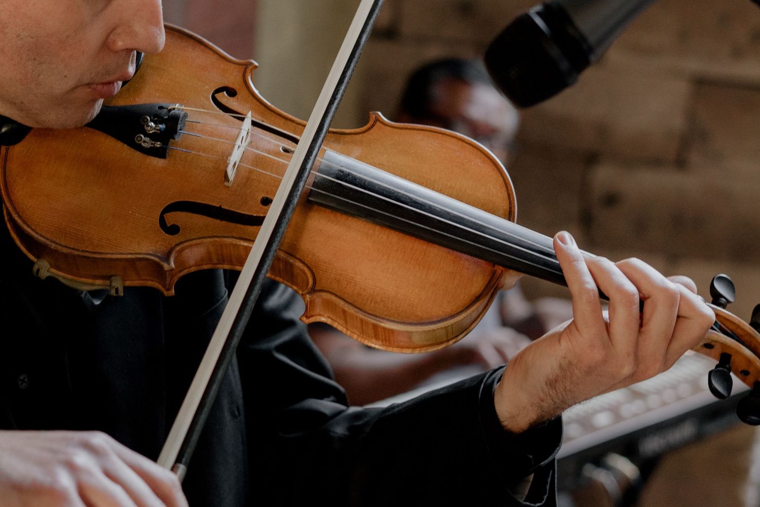 Musicians playing violins during an elegant wedding ceremony.