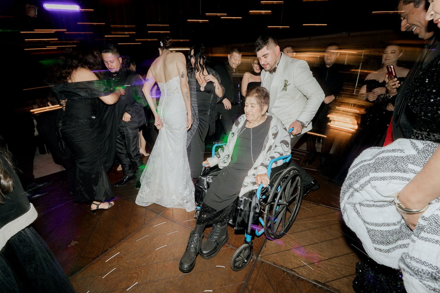 Wedding guests celebrating on the dance floor with sparklers and ambient lighting.