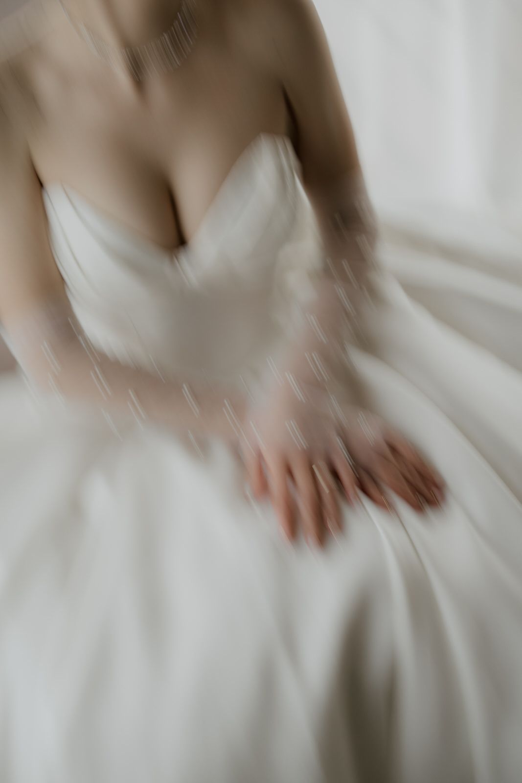 Dreamy soft-focus detail of a white wedding dress bodice with sweetheart neckline.