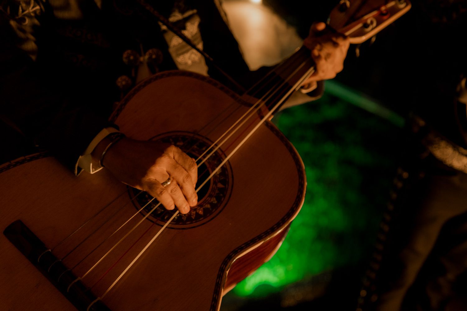Close-up shot of acoustic guitars illuminated by warm ambient lighting.