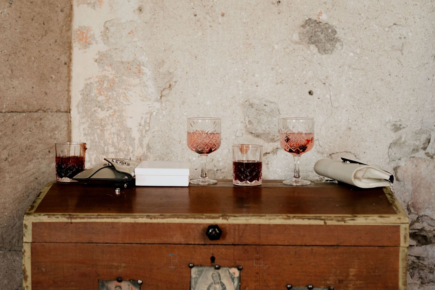 Vintage wooden buffet table against weathered stone wall at wedding reception.