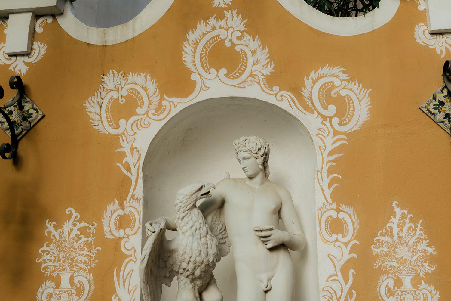 Ornate white and gold baroque wallpaper pattern with decorative scrollwork and floral motifs in a traditional style.