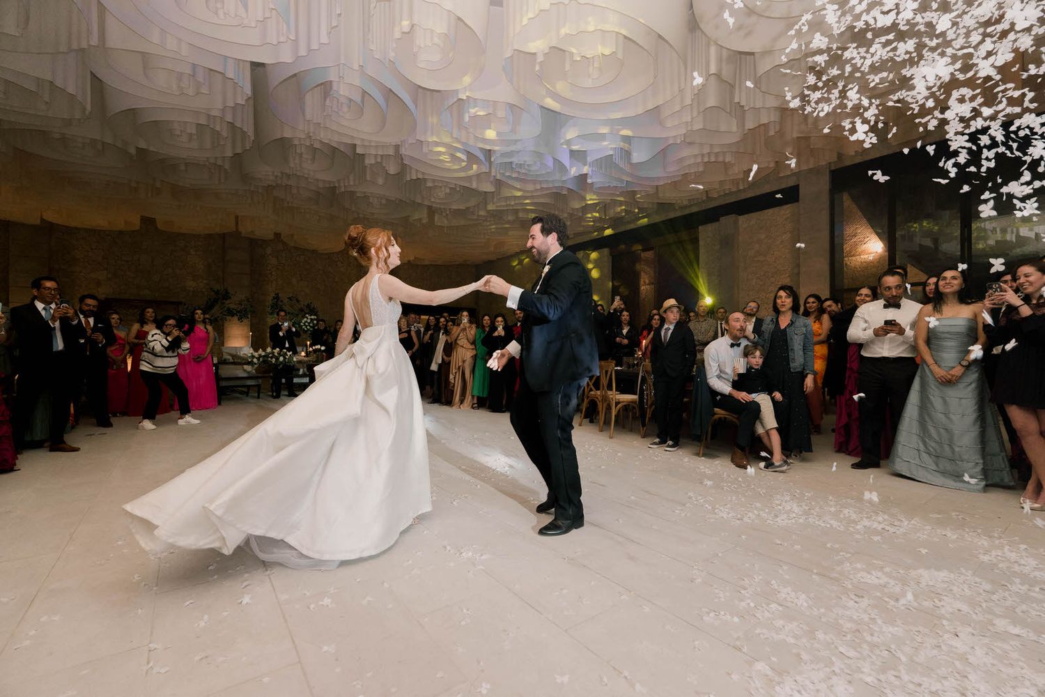 Confetti fills the air during a romantic wedding dance in an elegant reception venue.