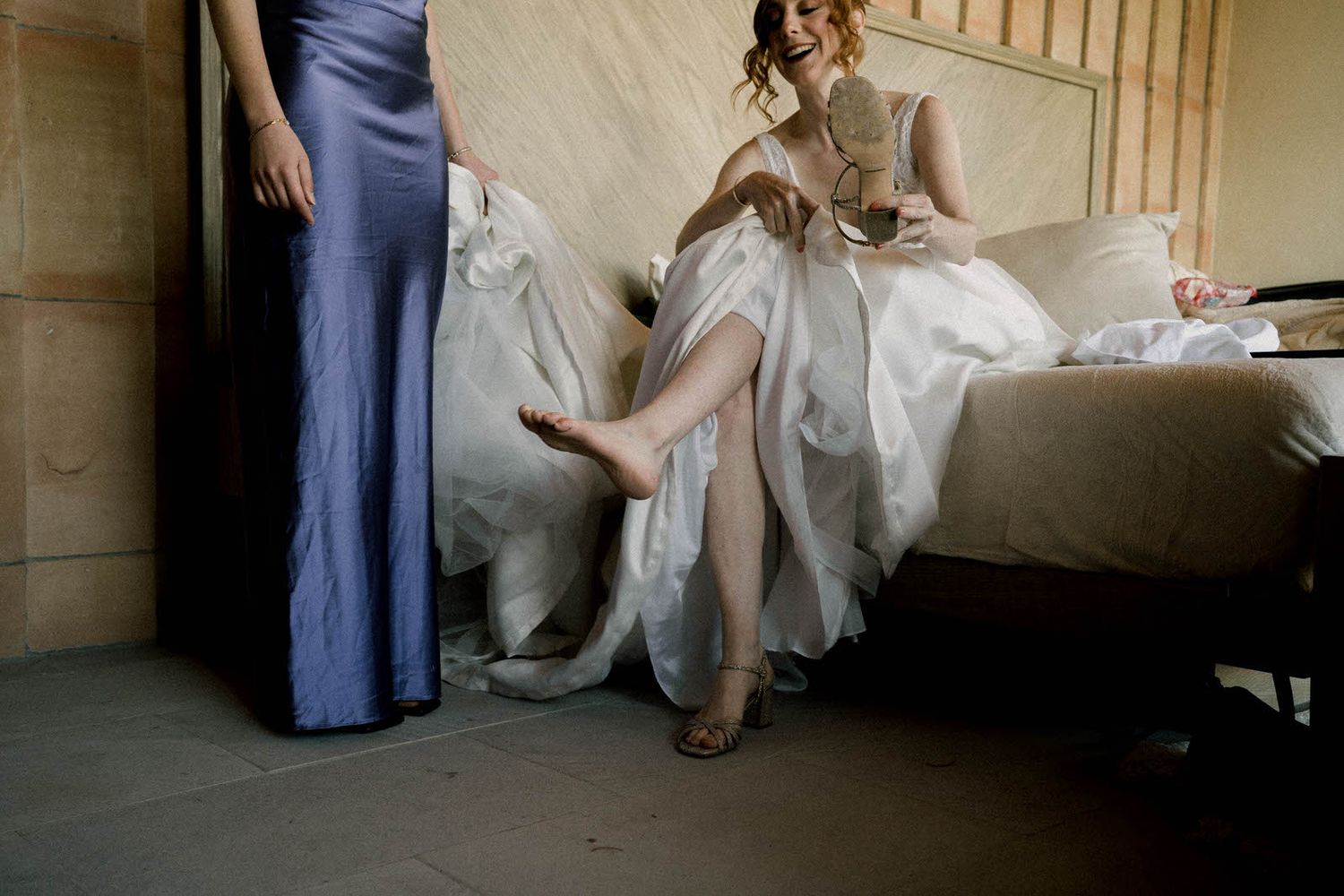 Someone in a white dress and blue dress sitting in an indoor space.