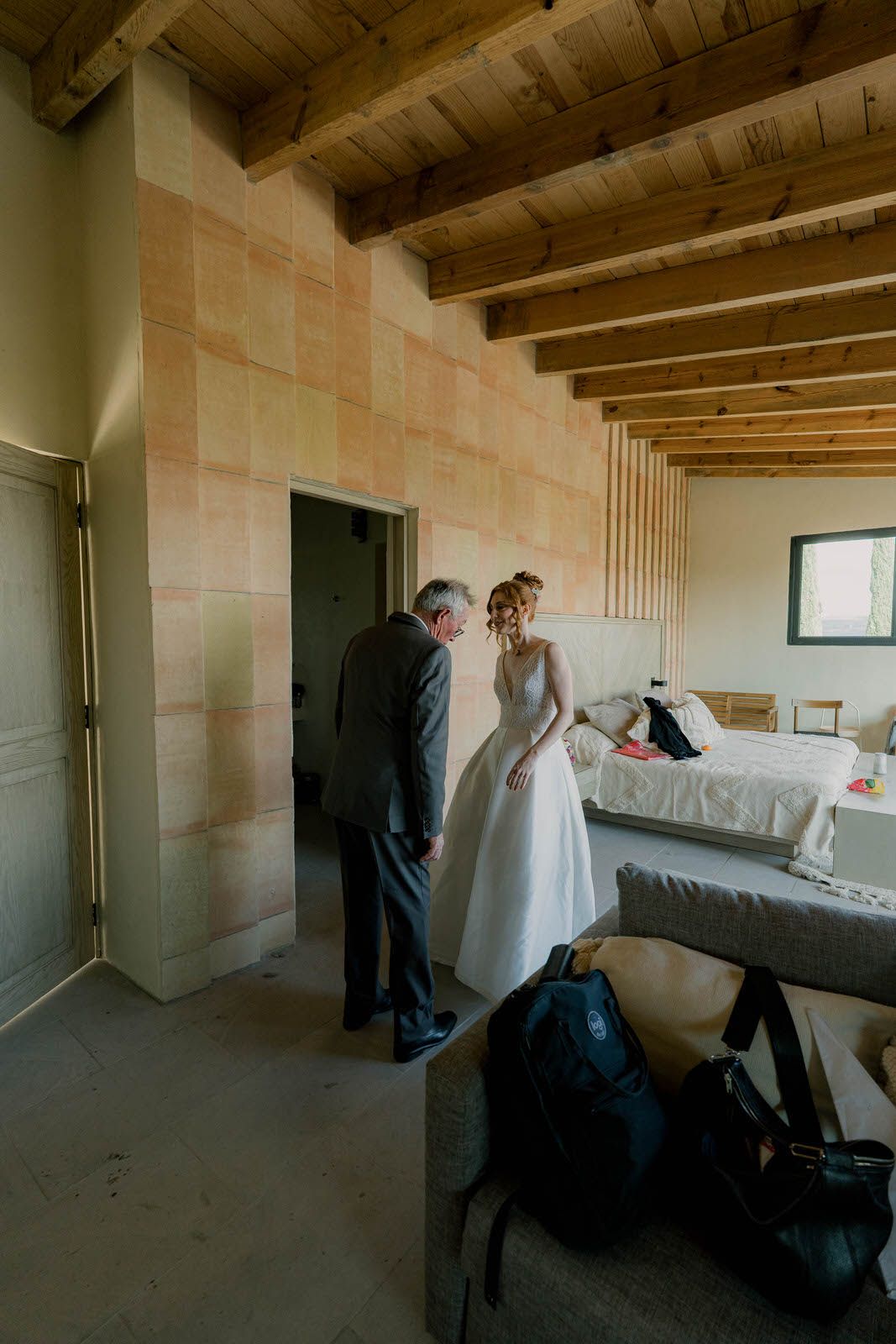 Spacious room with wooden ceiling beams and white walls in natural lighting.
