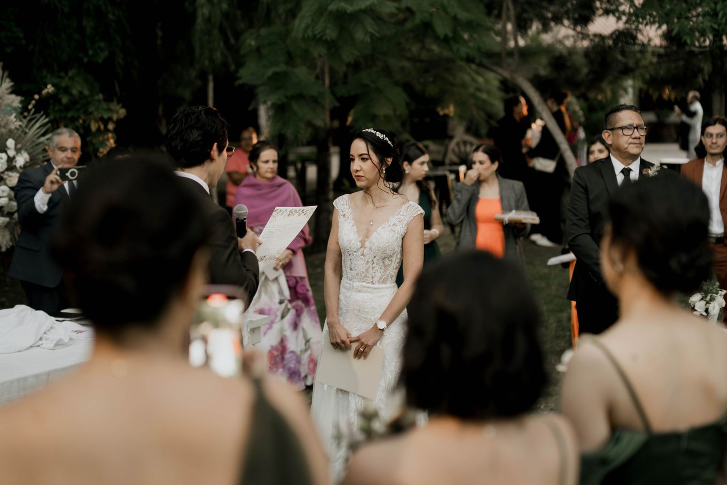Evening wedding celebration with guests gathered outdoors.