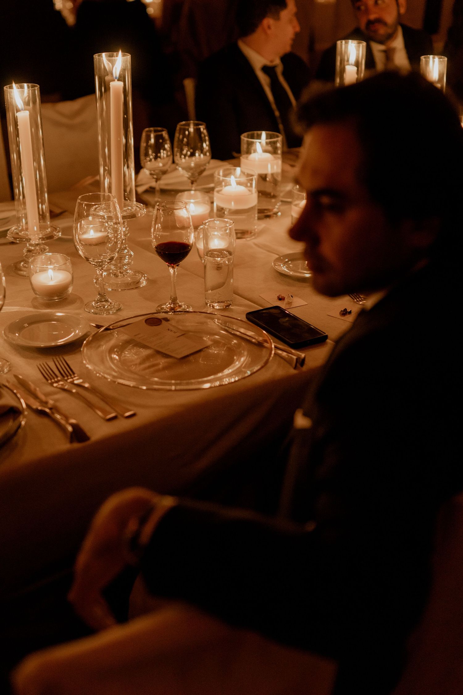 Intimate candlelit dinner setting with glowing votives and elegant table settings.